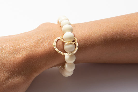 White Bone Beaded Bracelet With Two Solid 14k Yellow Gold Circle Charms Featured on Arm